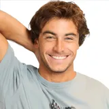 Remera gris de manga corta con estampado frontal de tres rostros y texto.