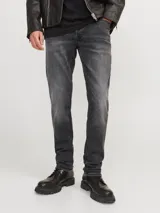 Jean de corte slim fit con tiro bajo, confeccionado en denim elástico de color gris oscuro con efecto lavado. Presenta diseño clásico de cinco bolsillos, cierre frontal con botón y costuras reforzadas.