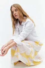 Maxi vestido amarillo con estampado floral blanco y rosa, de tirantes finos y corte holgado.