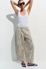 Pantalón estilo pijama de tiro medio, confeccionado 100% en algodón. Cuenta con cintura elástica, bolsillos laterales ocultos en la costura y diseño de corte barrel con estampado de lunares.