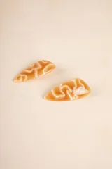 Par de broches triangulares color caramelo con diseño abstracto en blanco.