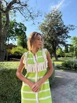 Vestido tejido en hilo de algodón, a rayas verticales verdes y blancas, con volados en los hombros y cierre frontal con botones.