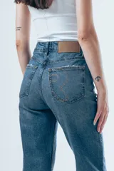 Jeans de tiro alto y corte recto, con diseño clásico de cinco bolsillos y cierre frontal con botón y cremallera.