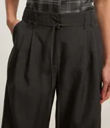 Pantalón pantalona de poliéster color gris oscuro, con cintura alta, corte amplio, pliegues frontales, trabillas y cinturón fino.