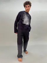 Pantalón de lana color gris oscuro con corte recto y detalle texturizado en las piernas laterales. Tiene pretina elástica a la cintura y un teñido degradé. Es parte del conjunto Alquimia.