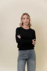 Buzo de punto color beige melange, de manga larga, cuello redondo y corte recto.