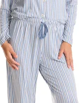 Conjunto de pijama compuesto por una remera de manga larga con escote en V, abertura frontal con botones y bolsillo aplicado, y un pantalón con cintura elástica y lazo de ajuste. Presenta un estampado animal print en tonos neutros.