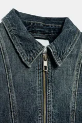 Campera bomber de denim en color gris oscuro con efecto lavado, cuello camisero, cierre frontal de cremallera metálica, bolsillos laterales ribeteados y terminaciones elásticas en puños y cintura.