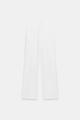 Pantalón de tiro alto confeccionado en tejido fluido, con diseño de pierna recta y holgada. Presenta pliegues frontales, trabillas para cinturón, bolsillos laterales y cierre frontal con botón.