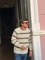 Sweater de punto con cuello redondo, diseño de rayas horizontales en tonos oscuros sobre base clara, de manga larga y calce cómodo.