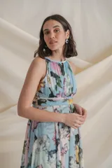 Vestido largo de crepe de seda estampado con flores en tonos celeste, rosa y verde. Tiene cintura drapeada y falda con paneles sueltos.