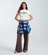 Pantalón de corte recto con textura sutil, confeccionado en tejido de poliéster con elastano. Presenta cintura media y una caída cómoda y fluida.