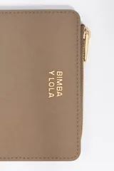 Billetera compacta de estructura blanda en color turquesa, con cierre de cremallera superior y logo metálico dorado en el frente.