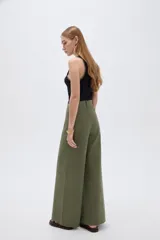 Pantalón jean verde militar, de tiro alto, corte ancho tipo wide leg y diseño de perneras amplias con costuras verticales decorativas.