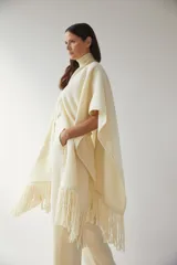 Ruana marrón con flecos y bolsillos. Terminaciones envivadas.