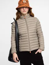 Campera acolchada Save The Duck modelo Carly, color beige, confeccionada en nylon y rellena con Plumtech. Tiene cuello alto, cierre bidireccional y bolsillos laterales con cierre invisible.