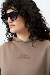 Canguro negro con capucha y bolsillo delantero. Presenta un bordado frontal y trasero con lettering “Mont Saint-Michel”.