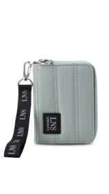 Billetera corta de diseño capitoneado con cierre perimetral y solapa frontal. Cuenta con compartimentos internos para tarjetas y billetes, e incluye una correa de mano desmontable.