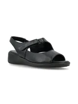 Sandalia de cuero negro con diseño de tiras anchas, ajuste mediante velcro y suela de plataforma baja.