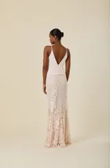 Vestido largo de fiesta con escote en V profundo y detalle de nudo en la cintura. La parte superior es de tela lisa y la falda presenta una superposición de tul con delicados bordados florales.