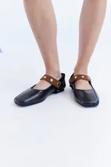Ballerinas de cuero bordó con puntera cuadrada, diseño destalonado y tira en el empeine decorada con tachas metálicas.