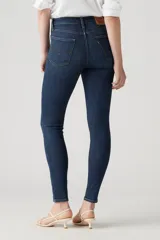 Jeans de tiro alto, color azul oscuro, corte ajustado en cadera y muslos, y pierna skinny.