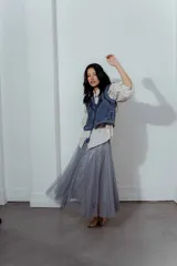 Pollera midi de tul gris con lentejuelas plateadas brillantes. Presenta una cintura elástica y una caída amplia con movimiento.