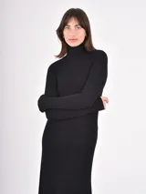Vestido midi de punto color negro, con cuello alto y mangas largas, de corte ajustado en la parte superior y falda ligeramente acampanada.