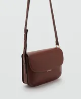 Bolso de hombro tipo bandolera en color marrón, con diseño estructurado de solapa, cierre metálico a presión y costuras decorativas en contraste. Incluye correa larga ajustable.