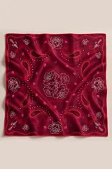 Pañuelo cuadrado de seda con acabado brillante, estampado con diseño paisley y rosas en color bordó y blanco. Presenta bordes terminados a mano.