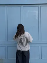 Remera gris de manga corta con corte regular, de la marca Kaboa Industries, con estampa en la espalda que presenta un esqueleto dentro de un ataúd rodeado por alas oscuras y las leyendas WAKE UP y Kaboa Industries.