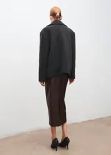 Falda midi de efecto piel, con diseño tipo lápiz, tiro medio y abertura posterior en el bajo. Cuenta con cierre de cremallera lateral.