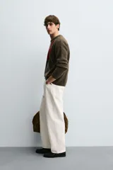 Jersey de punto con lana, corte relajado, cuello redondo y manga larga. Presenta un diseño de rombos en tonos marrón, beige y rojo con detalles bordados, y acabados en rib.