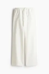 Pantalón de corte holgado en denim liviano de mezcla de lyocell y algodón. Modelo de tiro alto con elástico revestido y cordón para ajustar en la cintura, bolsillos laterales discretos y piernas rectas.