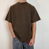 Remera de corte oversize confeccionada en tela pesada de algodón con efecto lavado y bordes deshilachados en las mangas.