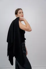 Ruana negra de tejido de punto grueso, confeccionada en 100% baby alpaca.