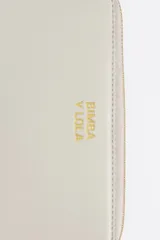 Billetera rígida de color negro con cierre de cremallera perimetral. Presenta el logo metálico de Bimba y Lola en color dorado en el frente y un tirador de cordón trenzado en tonos marrón y amarillo. El interior cuenta con compartimentos para tarjetas y un monedero con cierre.