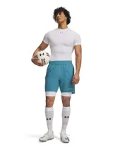 Short deportivo Under Armour de la línea Challenger, diseñado para fútbol. Presenta un color azul petróleo con detalles gráficos sutiles en la parte inferior y logo de la marca. Cuenta con cintura elástica con cordón interno, bolsillos laterales y un diseño ligero con perforaciones para ventilación.