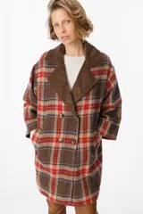 Blazer de corte relajado con estampado de cuadros en tonos marrones, rojos y azules. Presenta solapas de pana en color marrón chocolate, cierre frontal con botones y bolsillos laterales.