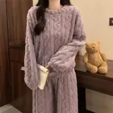 Conjunto de pijama de dos piezas confeccionado en plush suave con textura de ochos. Incluye una remera de manga larga con cuello redondo y un pantalón de corte recto con cintura elástica.