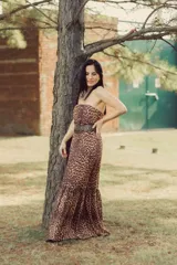 Vestido largo strapless con estampado animal print y cinturón ancho con apliques metálicos.