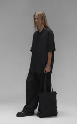 Camisa de manga corta con calce oversize, confeccionada en tejido de lyocell, con cuello clásico y cierre frontal de botones.