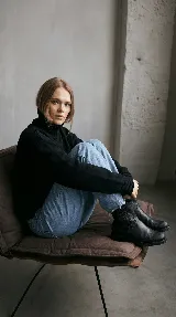 Bota corta tipo chelsea de cuero vacuno color negro, con elásticos laterales, taco cuadrado de madera y suela de caucho.