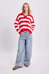 Sweater de punto a rayas horizontales rojas y blancas, con cuello polo y mangas largas.