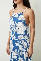 Vestido midi de corte holgado con estampado floral en tonos azul y blanco, presenta escote halter con breteles finos y diseño sin mangas.