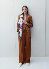 Pantalón de vestir de corte recto y tiro medio, color marrón, con pinzas frontales y bolsillos laterales.