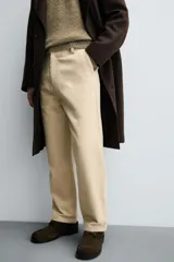 Pantalón de corte regular fit confeccionado en pana de algodón color beige, con bolsillos frontales, bolsillos traseros de plastrón y cierre frontal con cremallera y botón.