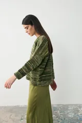 Sweater de tejido de punto con diseño oversize, cuello en V y mangas largas. Presenta un patrón de rayas horizontales en tonos verdes y marrones.