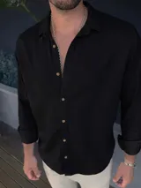 Camisa de lino color negro con cuello clásico y botones frontales en tono madera.