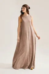 Maxi vestido negro sin mangas, con cuello redondo y silueta suelta que se abre en A hacia el ruedo. Confeccionado en 100% algodón, incluye aplique trasero en forma de X.